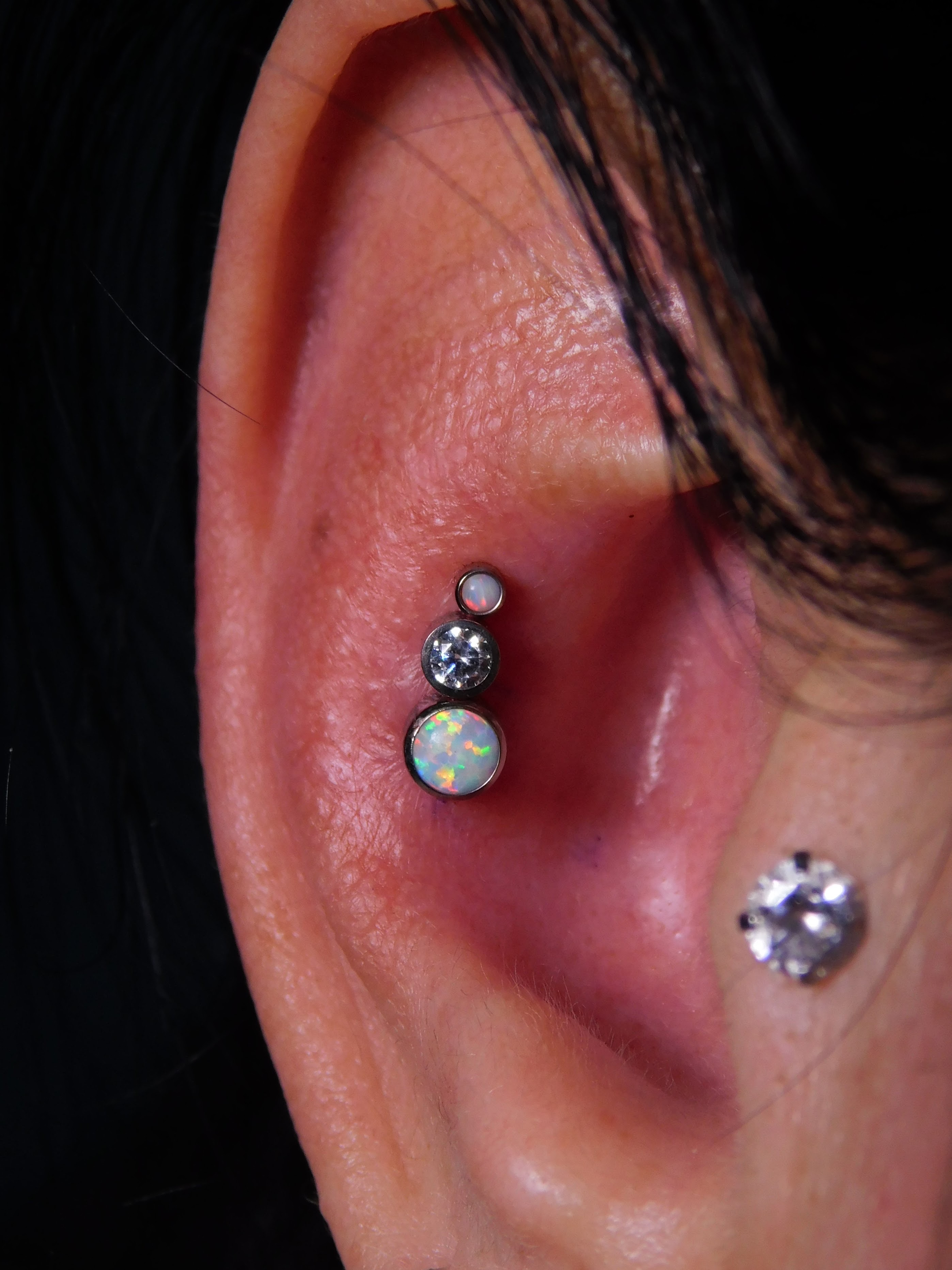 Tragus and helix ear piercings with small sterling silver hoops and bars