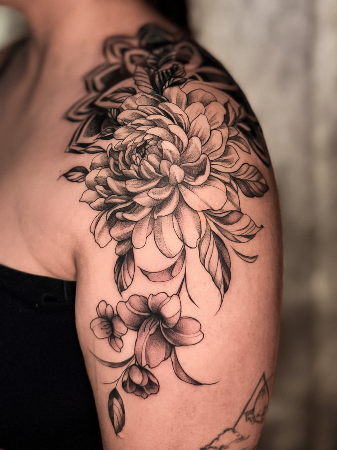 Black and Grey floral shoulder tattoo by Eliana Brito at Diroka Tattoo Studio