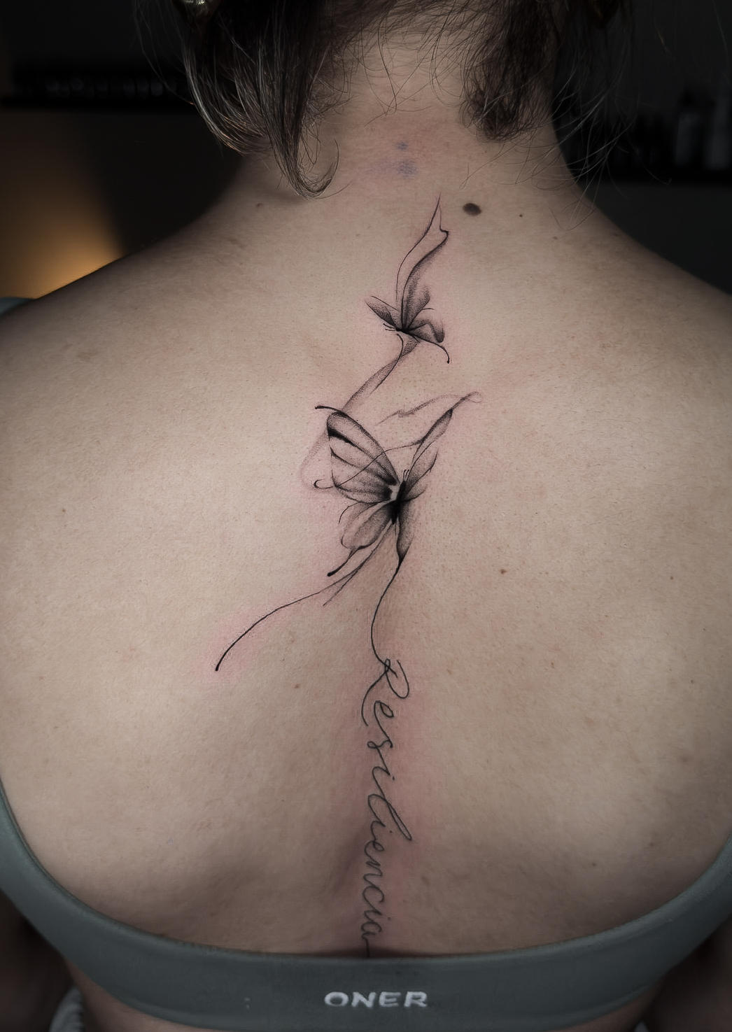 Fine line butterfly spine tattoo by Julian at Diroka Tattoo Studio